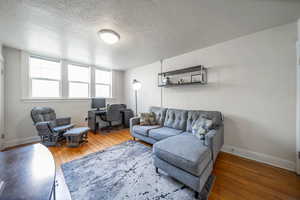 Living area featuring light wood-style floors, an office area, and a textured ceiling