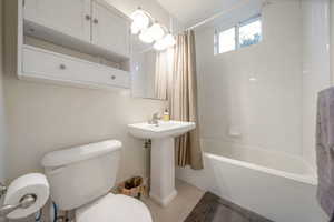 Bathroom with shower / tub combo and toilet