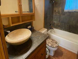 Bathroom with washtub / shower combination, a textured wall, dark tile patterned flooring, vanity, and wooden ceiling