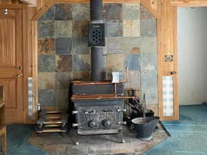 Detailed view of a wood stove, carpet flooring, and wood walls