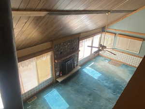 Unfurnished living room featuring lofted ceiling and a fireplace