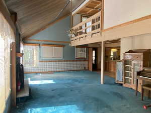 Unfurnished living room with high vaulted ceiling
