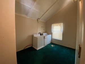 Laundry room with washer and dryer and dark colored carpet