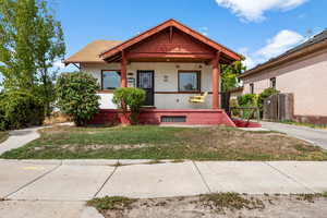 View of front of home with a porch and brick siding