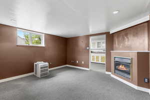 Below grade area with a glass covered fireplace, carpet, and recessed lighting