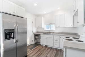 Kitchen featuring stainless steel refrigerator with ice dispenser, white cabinetry, light countertops, and recessed lighting