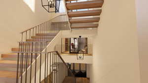 Stairs with wood finished floors and a chandelier