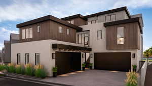 Contemporary house featuring an attached garage, stucco siding, and driveway
