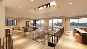Corridor featuring plenty of natural light, recessed lighting, light wood-style floors, and an upstairs landing