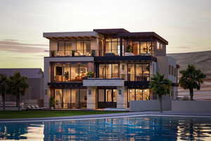 Rear view of house with a balcony, a community pool, and stucco siding
