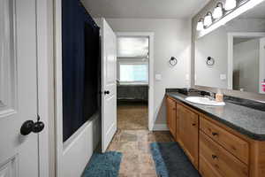 Main Bedroom On suite bathroom featuring vanity, shower / bath combination with curtain, ensuite bathroom, and a textured ceiling