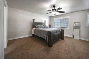 Bedroom featuring carpet, ceiling fan, and a textured ceiling