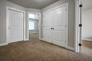 Hallway featuring carpet flooring and a textured ceiling