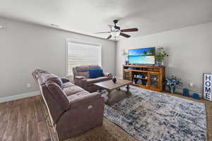 Living area with ceiling fan, a textured ceiling, and wood finished floors