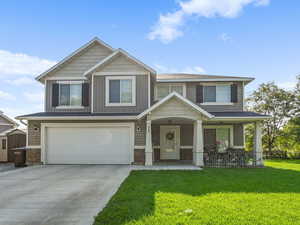 Craftsman inspired home with covered porch, concrete driveway, a garage, and stone siding