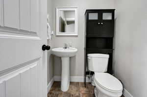 Half bathroom with toilet and baseboards
