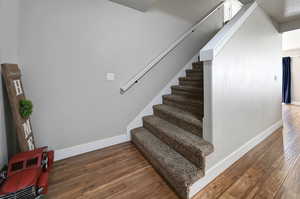 Stairway featuring wood finished floors and baseboards