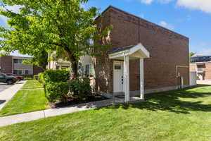 View of front of house featuring a front lawn and brick siding