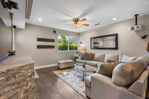Living area with dark wood-type flooring, ceiling fan, and recessed lighting
