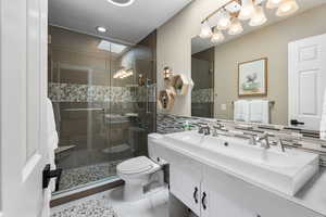 Bathroom featuring double vanity and a shower stall