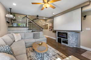 Home theater featuring a fireplace, dark wood-style floors, a ceiling fan, and recessed lighting