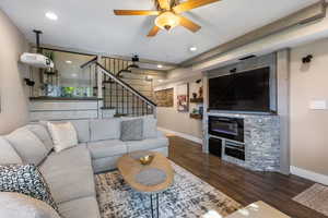 Living room with stairway, dark wood-style floors, ceiling fan, and recessed lighting