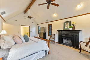 Bedroom featuring beam ceiling, high vaulted ceiling, a fireplace with flush hearth, and a ceiling fan