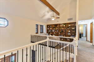 Staircase with beam ceiling, high vaulted ceiling, carpet floors, and a ceiling fan