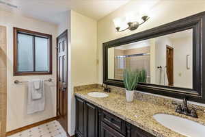 Bathroom featuring a stall shower and double vanity