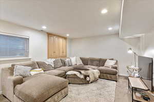Living area with recessed lighting and light carpet
