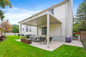 Back of property with a patio, an outdoor living space, brick siding, and a gate