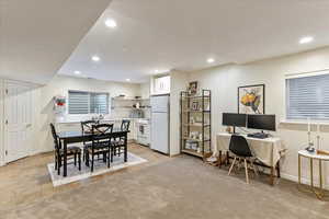 Dining space with recessed lighting, light tile patterned floors, a desk, and light carpet