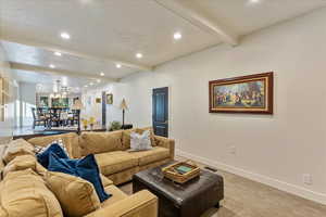 Living room featuring beam ceiling, recessed lighting, and light colored carpet