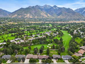 Aerial view of residential area featuring a local golf course and mountains