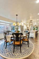 Dining area featuring a chandelier, a textured ceiling, light wood finished floors, and recessed lighting
