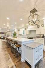 Kitchen with a chandelier, white cabinets, pendant lighting, recessed lighting, and a textured ceiling