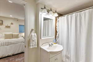 Full bath featuring ensuite bathroom, vanity, curtained shower, and recessed lighting
