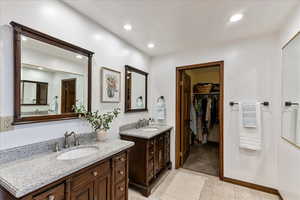 Full bathroom featuring two vanities, recessed lighting, a spacious closet, and light tile patterned floors