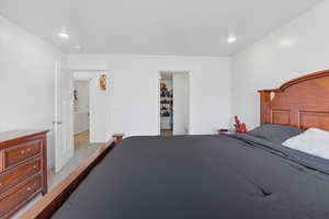 Carpeted bedroom with recessed lighting and a spacious closet