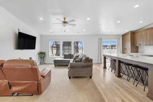 Living room featuring healthy amount of natural light, recessed lighting, a ceiling fan, and light wood finished floors