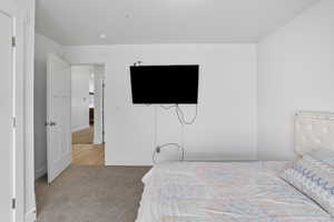 Bedroom featuring light colored carpet and baseboards