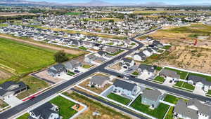 Aerial view of property and surrounding area with nearby suburban area and a mountainous background