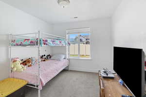 Bedroom with light colored carpet and baseboards