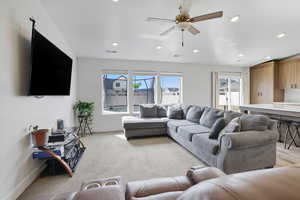 Living room with light carpet, ceiling fan, and recessed lighting