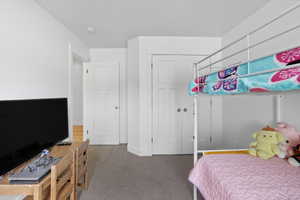 Carpeted bedroom with a closet and baseboards