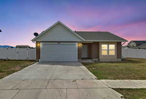 Single story home with concrete driveway, an attached garage, and a gate