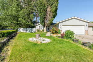 View of front facade with brick siding, driveway, and a garage