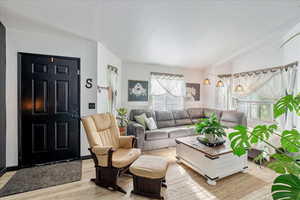 Living room featuring light wood-type flooring and a textured ceiling