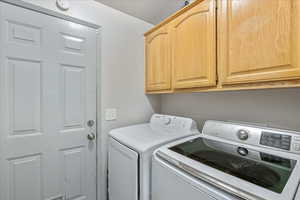 Laundry room with separate washer and dryer and cabinet space