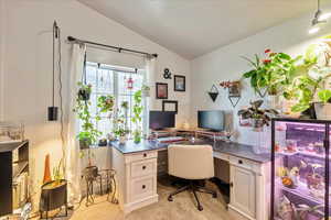 Office featuring lofted ceiling and light carpet